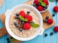 Avena con frutos rojos y pasas. Aunque la leche de avena engorda, este desayuno parece saludable y delicioso.