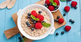 Avena con frutos rojos y pasas. Aunque la leche de avena engorda, este desayuno parece saludable y delicioso.