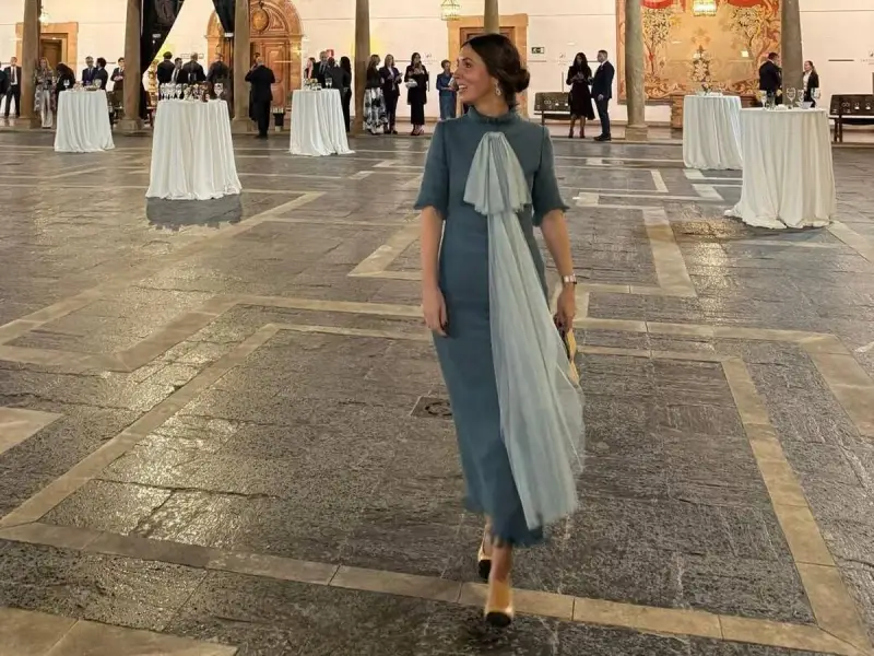 Elegante mujer con vestido azul claro y velo, lista para los Premios Princesa de Asturias.