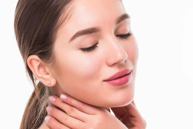 Rostro de mujer con piel suave y labios rosados, luciendo un efecto botox natural.